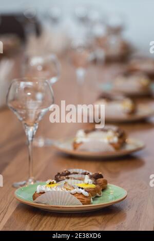 tavolo servito per degustazione di cibo e vite. Eclair con diverse ganache e glassare con diversi condimenti Foto Stock