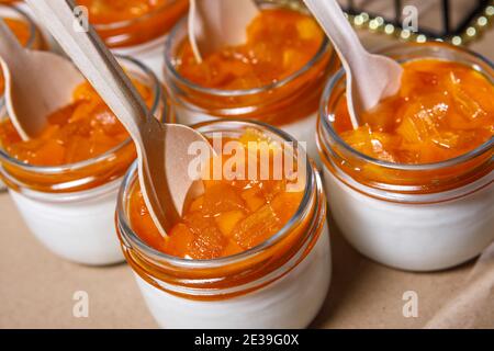 Frullato di panna montata e persimmon in un vaso di vetro. Cucchiai in legno in vasi. Foto Stock