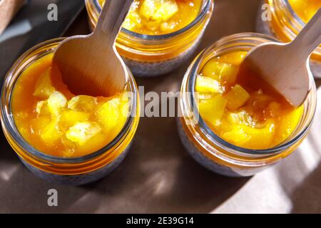 Frullato di panna montata e persimmon in un vaso di vetro. Cucchiai in legno in vasi. Foto Stock