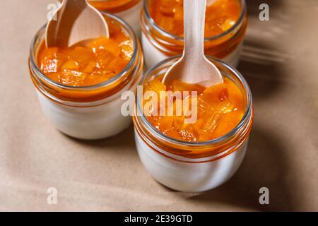 Frullato di panna montata e persimmon in un vaso di vetro. Cucchiai in legno in vasi. Foto Stock