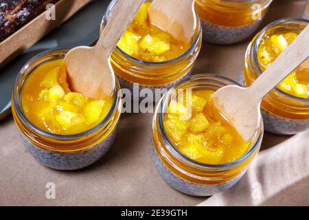 Frullato di panna montata e persimmon in un vaso di vetro. Cucchiai in legno in vasi. Foto Stock