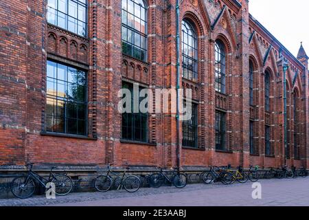 Biciclette parcheggiate di fronte al muro di Copenaghen Biblioteca universitaria (progettata da Johan Daniel Herholdt) Accanto all'edificio principale dell'Università Foto Stock