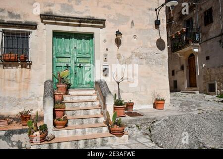 Una porta in legno, colorata e dipinta di verde, fuori da una casa nel centro storico di Matera, Italia. Foto Stock