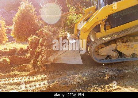 Mini bulldozer lavora con la terra mentre facendo lavori di ingegneria naturalistica sulla costruzione di suolo in movimento Foto Stock