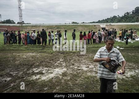 Mamuju, Sulawesi Occidentale, Indonesia. 17 gennaio 2021. Le vittime del terremoto si riuniscono allo stadio di calcio di Manakarra per ricevere aiuti sotto forma di cibo e abbigliamento. Centinaia di residenti sono stati costretti a vivere in tende rifugiate dopo che le loro case sono state distrutte dal terremoto di grandezza del 6.2 che ha colpito Sulawesi Ovest. Credit: Herwin Bahar/ZUMA Wire/Alamy Live News Foto Stock