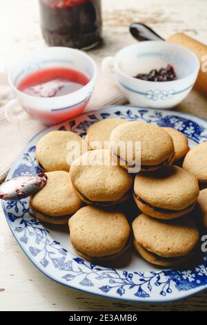 Biscotti fatti in casa con marmellata o confettura di prugne di frutta in un piatto - primo piano vista frontale cotta cibi dolci tradizionali ricetta - concetto di alimentazione sana Foto Stock