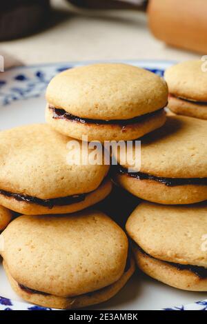 Biscotti fatti in casa con marmellata o confettura di prugne di frutta in un piatto - primo piano vista frontale cotta cibi dolci tradizionali ricetta - concetto di alimentazione sana Foto Stock