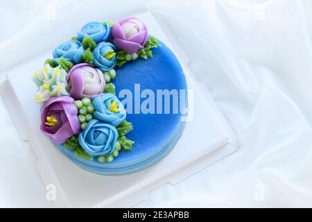 Torta minimale fatta da torta dolce di strato di panda e decorata fiori carini di wite su panno bianco. Dessert tailandese Foto Stock