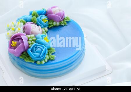 Torta minimale fatta da torta dolce di strato di panda e decorata fiori carini di wite su panno bianco. Dessert tailandese Foto Stock