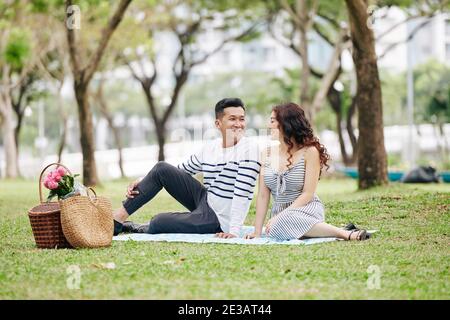 Bella giovane fidanzata e ragazza seduta in prestito in città parcheggia durante un picnic romantico Foto Stock