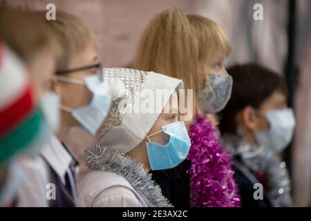 24 dicembre 2020. Bielorussia, la città di Gomil. Vacanze di Natale in città durante l'epidemia di coronavirus. Un ragazzo che indossa un cappello di babbo natale e un me Foto Stock