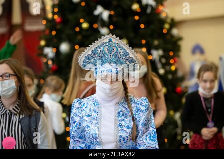 24 dicembre 2020. Bielorussia, la città di Gomil. Vacanze di Natale in città durante l'epidemia di coronavirus. Russo Snow Maiden in una maschera medica a. Foto Stock