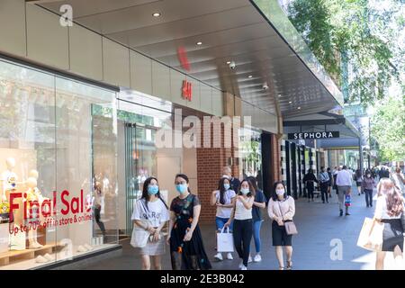 Ragazze donne a Sydney indossare maschere viso durante Covid 19 Pandemia e camminare lungo Pitt Street nel centro della città, NSW, Australia Foto Stock