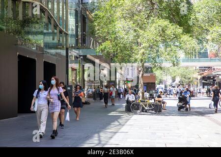 Fare shopping in Pitt Street a Sydney due amici adolescenti asiatici Indossando maschere al di fuori mentre camminano attraverso Sydney, Australia Foto Stock