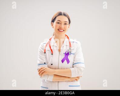 4 Febbraio Giornata Mondiale del cancro. Medico femminile su fondo grigio parete. Migliorare la conoscenza delle persone affette da malattie tumorali. Foto Stock