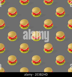 Fast food. Hamburger giocattolo in plastica per bambini con motivo senza cuciture, insalata, pomodoro, carne su sfondo grigio. Non utile Foto Stock