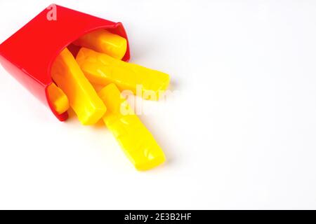 Fast food in plastica, patatine fritte giocattolo su sfondo bianco. Malsano. Non organico Foto Stock