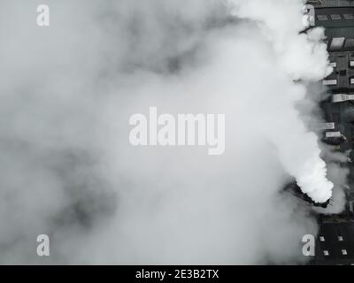 Vista dall'alto verso il basso di una grande fabbrica di fumo e vapore. Foto Stock