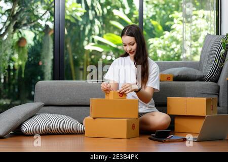 Venditore preparare per l'invio di merce al cliente dopo il controllo dell'ordine. Foto Stock