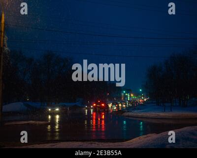 Notte inverno città depressive vista con luce notturna a caduta di neve Foto Stock