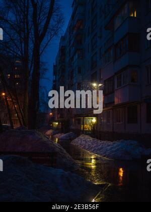 Notte inverno città depressive vista con luce notturna a caduta di neve Foto Stock