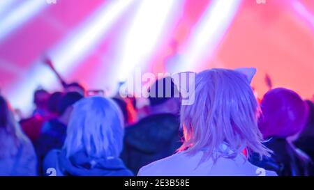 Ragazza adolescente festeggiando al concerto rock di fronte al palco - vista posteriore Foto Stock