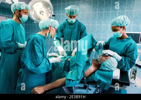 Gruppo di medici chirurgo al lavoro in sala operatoria. Foto Stock