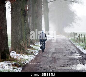 uomo in mountain bike in inverno su strada sterrata vicino a utrecht in olanda Foto Stock