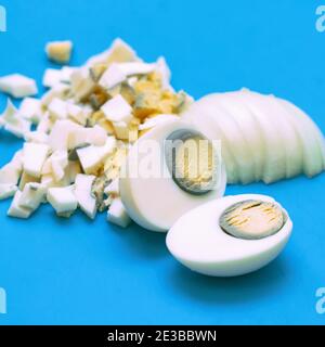 Uova bollite tagliate o tagliate a pezzi piccoli su un Tagliere Foto Stock