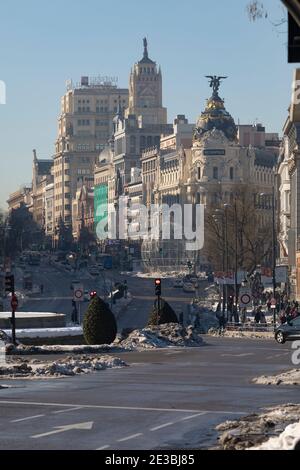 Madrid, Spagna - 17 gennaio 2021: Vista generale delle strade di Alcalá e Gran Vía con l'edificio Metropolis, ancora con una certa quantità di neve accumulata e sporca Foto Stock