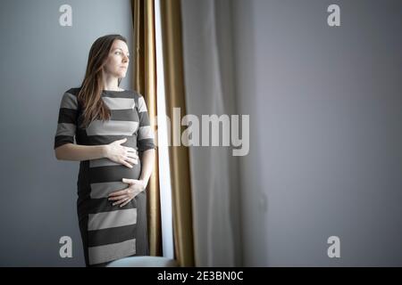 Preoccupata donna incinta singola che si preoccupa del suo futuro Foto Stock