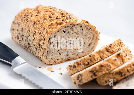 Pane di grano a grani multipli affettato su tavola di marmo. Vista in primo piano. Consistenza del pane intero di grano Foto Stock