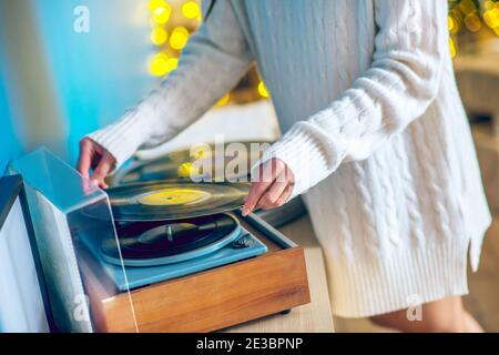 Donna in vestiti bianchi che mette un record sopra Foto Stock