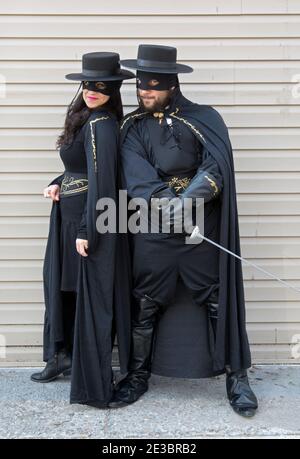 Una coppia ebrea ortodossa a Brooklyn celebra uno dei costumi della vacanza Purim vestendo i costumi di MR & Mrs Zorro. A Brooklyn, New York. Foto Stock