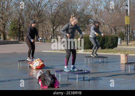 3 donne in una classe di rimbalzo che combina movimenti vigorosi mentre saltano su un piccolo trampolino. In Flushing Meadows Corona Park a Queens, New York. Foto Stock