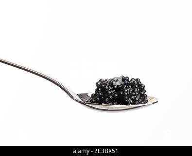 caviale fresco di pesce gatto nero granato in cucchiaio di metallo su sfondo bianco, primo piano Foto Stock