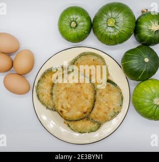 Zucchine rotonde verdi in milanesi al forno o fritte, gastronomia argentina Foto Stock