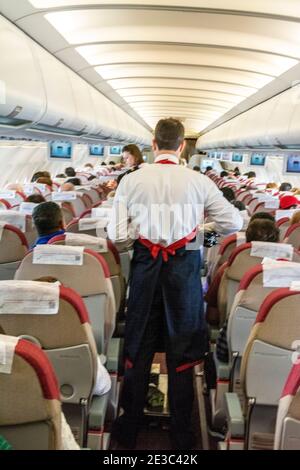 L'equipaggio di cabina serve rinfreschi in classe economica su un Airbus 320 - TAM Linhas all'aeroporto internazionale di Brasilia, capitale del Brasile. Foto Stock