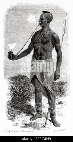 Karague uomo che fuma tabacco in un tubo, Uganda, Africa. Antico XIX secolo inciso da le Tour du Monde 1864 Foto Stock