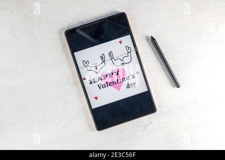 Tablet computer con cuore rosa e iscrizione Buon San Valentino. Tablet PC con Valentine e penna stilo. Decorazione di San Valentino. Concetto di San Valentino. Foto Stock