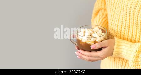 Donna che tiene una tazza grande di cacao caldo o cioccolato con marshmallow. Banner con spazio per il testo Foto Stock