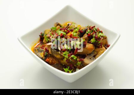 Un stufato di carne, patate, funghi e un mix di peperoni serviti in una ciotola bianca, pasto delizioso Foto Stock