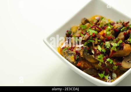 Un stufato di carne, patate, funghi e un mix di peperoni serviti in una ciotola bianca, pasto delizioso Foto Stock