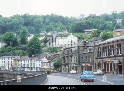 Matlock Bath 1981 Matlock Bath Derby Road (A6) Derbyshire 1981 traffico e persone a piedi e shopping su Derby Road passato negozi case caffè e negozi di articoli da regalo nel popolare villaggio di Matlock Bath Derbyshire Peak District Parco Nazionale Derbyshire Inghilterra Regno Unito GB Europa Foto Stock