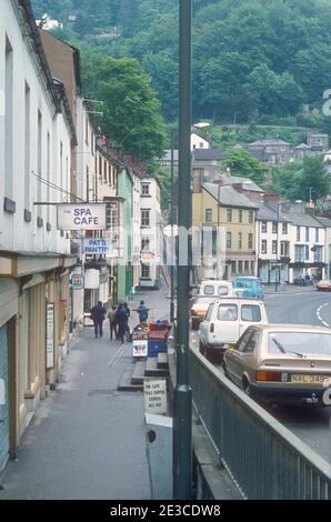 Matlock Bath 1981 Matlock Bath Derby Road (A6) Derbyshire 1981 traffico e persone a piedi e shopping su Derby Road passato negozi case caffè e negozi di articoli da regalo nel popolare villaggio di Matlock Bath Derbyshire Peak District Parco Nazionale Derbyshire Inghilterra Regno Unito GB Europa Foto Stock