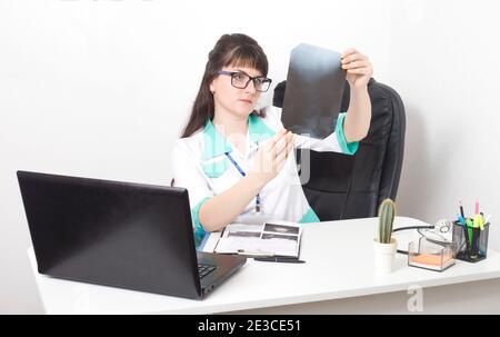 Il medico andrologo esamina un'immagine radiografica della colonna vertebrale. Trattamento dell'artrite e della gotta, sfondo. Clinica medica, osteoporosi Foto Stock