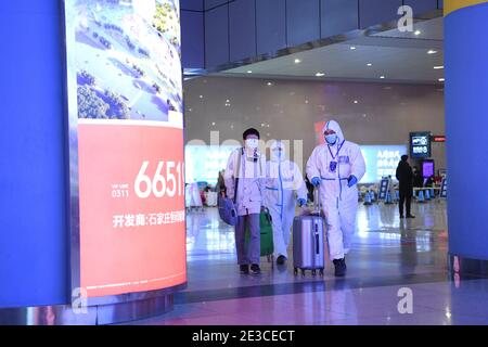 (210118) -- SHIJIAZHUANG, 18 gennaio 2021 (Xinhua) -- pilota di viaggio volontario Fan Yuejia (R) accompagna un passeggero di ritorno fuori dalla stazione ferroviaria di Shijiazhuang per un servizio di corsa gratuito in mezzo alla pandemia COVID-19 a Shijiazhuang, provincia di Hebei, 18 gennaio 2021. Poiché tutti gli altri servizi di trasporto pubblico a Shijiazhuang sono stati sospesi per scopi di prevenzione e controllo COVID-19, i conducenti locali hanno fatto passi avanti e si sono volontari per aiutare. Guidato da Fan Yuejia, di 36 anni, il team di 800 piloti volontari offre corse gratuite ai viaggiatori che arrivano Foto Stock