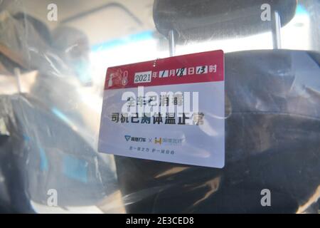(210118) -- SHIJIAZHUANG, 18 gennaio 2021 (Xinhua) -- una scheda informativa che rassicura i passeggeri che il viaggio sarà COVID-sicuro è messo in un'auto di pilota di guida in volo volontario a Shijiazhuang, la provincia di Hebei della Cina del nord, 18 gennaio 2021. Poiché tutti gli altri servizi di trasporto pubblico a Shijiazhuang sono stati sospesi per scopi di prevenzione e controllo COVID-19, i conducenti locali hanno fatto passi avanti e si sono volontari per aiutare. Guidato da Fan Yuejia, di 36 anni, il team di 800 piloti volontari offre corse gratuite ai viaggiatori che arrivano in città in corsa verso i cinesi Foto Stock