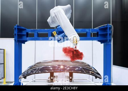 Spray di verniciatura del braccio robotico sulla parte automobilistica. Concetto di produzione ad alta tecnologia. Foto Stock