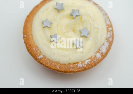 Torte di pasta al burro con un mangimiolo ripieno di frutti di vite speziati, condite con crema al brandy e una spolverata dolce, torte di mince tradizionali Foto Stock